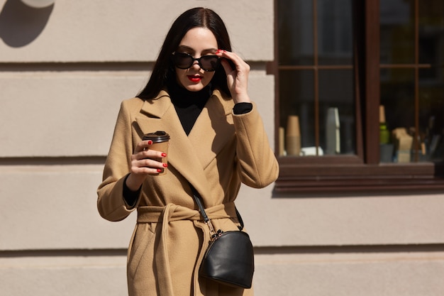 Outdoor shot of attractive young woman wearing coat