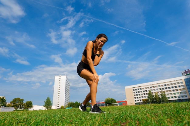 Colpo all'aperto dell'atleta della giovane donna che corre sulla pista. sportiva professionista durante la sessione di allenamento in esecuzione.