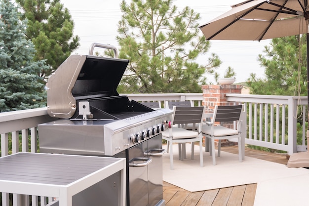 Outdoor six-burner gas grill on the back patio of a luxury single-family home.