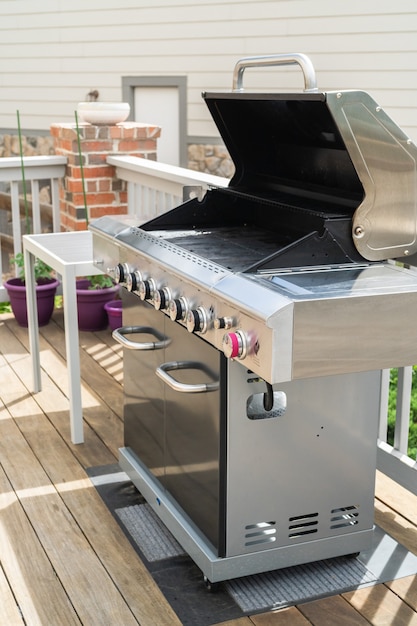 Outdoor six-burner gas grill on the back patio of a luxury single-family home.