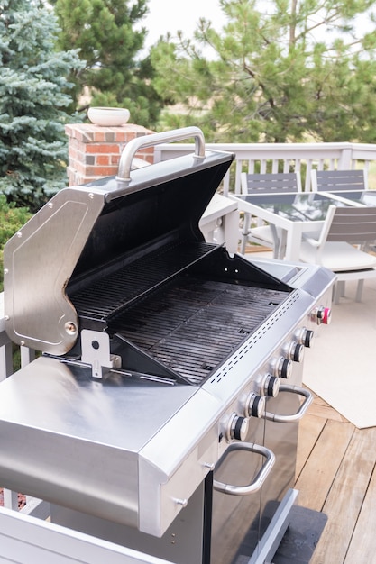 Outdoor six-burner gas grill on the back patio of a luxury single-family home.