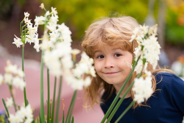 Outdoor small child boy portrait on the meadow Little cute kid with flowers in a garden Children play outdoors Kid play outdoor Spring kids portrait funny face