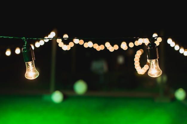 Photo outdoor string lights hanging on a line in backyard