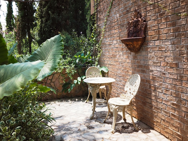 Outdoor summer garden decoration with vintage chairs and table furniture.