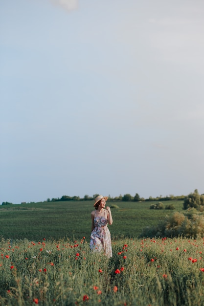 バスケットイチゴ、麦わら帽子と十代の少女の夏の屋外の肖像画。田舎道の女の子、背面図。自然の背景、田園風景、緑の牧草地、カントリースタイル