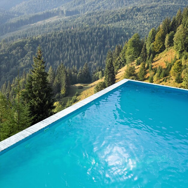 Outdoor swimming pool at luxury resort and beautiful view of mountains on sunny day