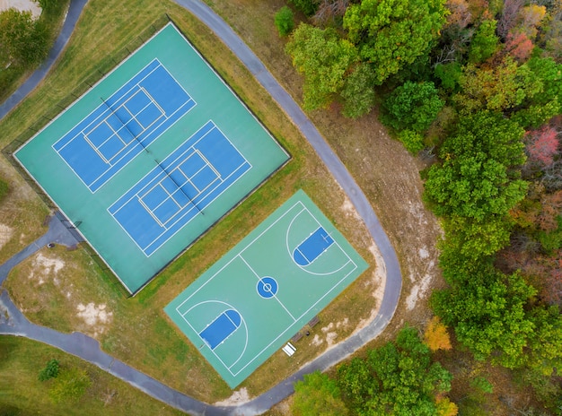 Outdoor tennis court and basketball field in the park from a height in autumn