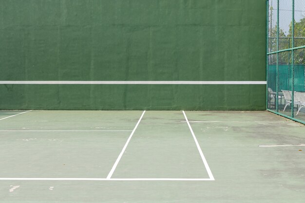 Outdoor tennis court and green knock board with white lines