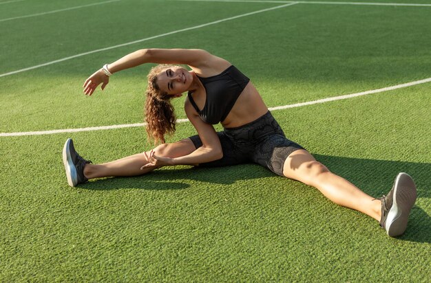 Outdoor training. attractive sexy fitness model warms up and stretches the muscles before training