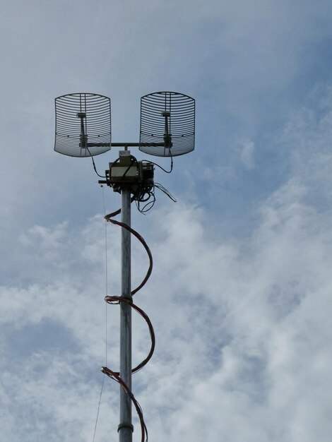 Outdoor wireless parabolic directional antennas on pole againts cloudy sky