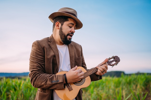 All'aperto di un giovane latinoamericano che suona cavaquinho o ukulele. musicista brasiliano.