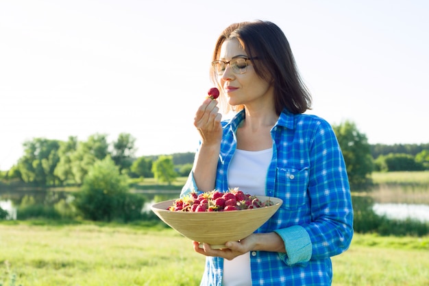 Outdoor zomer portret van volwassen vrouw met aardbeien