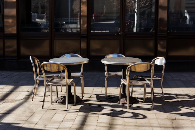 Outdoors empty cafe tables and chairs on a sunny day