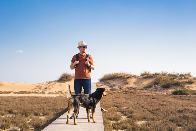 かわいい犬と一緒に旅行する男のアウトドアライフスタイルのイメージ。観光の概念。