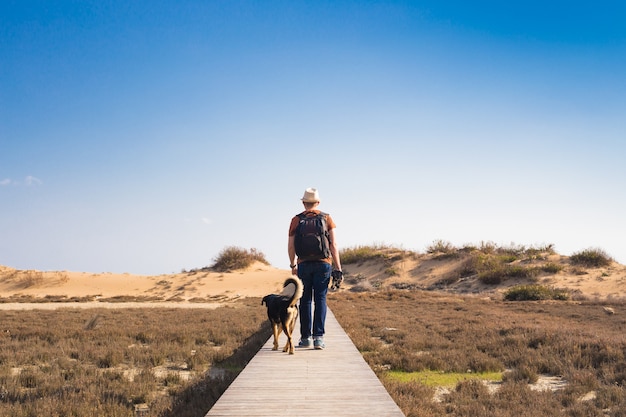 かわいい犬と一緒に旅行する男のアウトドアライフスタイルのイメージ。観光の概念。