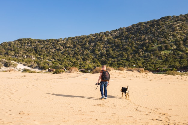 かわいい犬と一緒に旅行する男のアウトドアライフスタイルのイメージ。観光の概念。