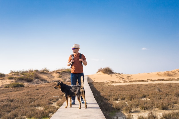 Outdoors lifestyle image of travelling man with cute dog. 