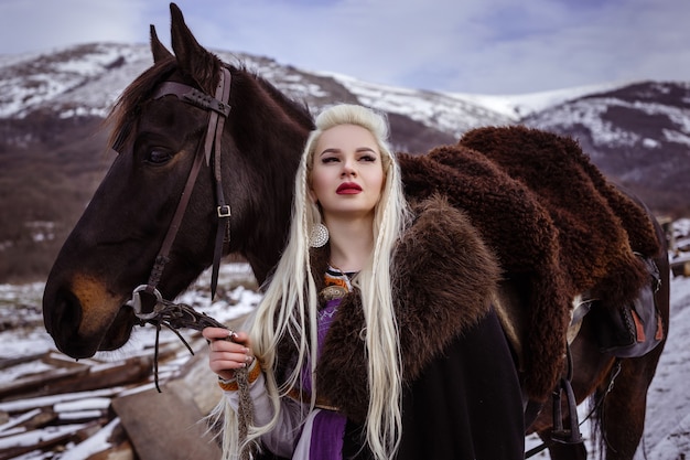 All'aperto ritratto di bella donna furiosa guerriero scandinavo allo zenzero in vestiti con collo di pelliccia