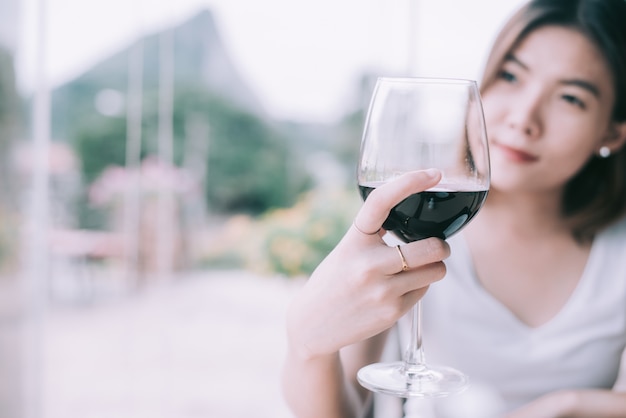 美しいワインの試飲観光女性の屋外のポートレート。若い女性がワインを飲む