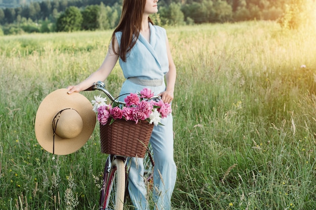 Outdoors portrait of beautiful woman which holds a bicycle 