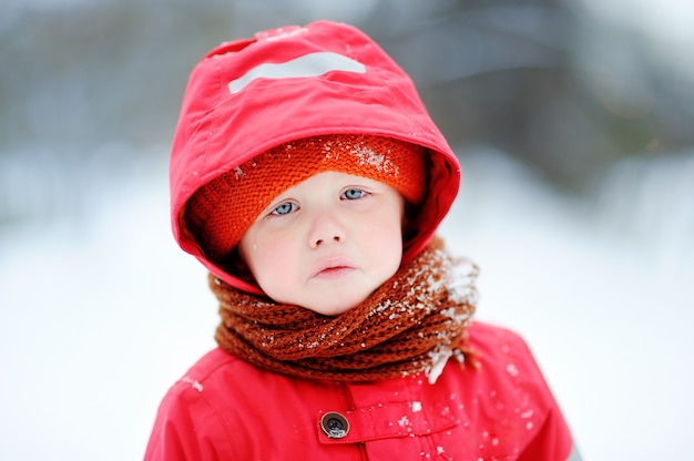 Outdoors portrait of sad crying little boy in winter. Unhappy lonely child