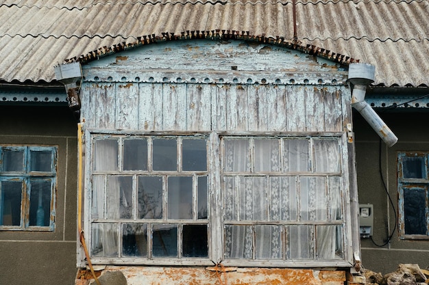 Outdoors shot of small windows of a wooden veranda of an old village house