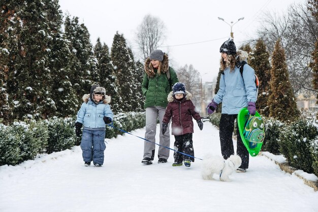 Photo outdoors winter activities for family friends happy family friends two women two boy kids and