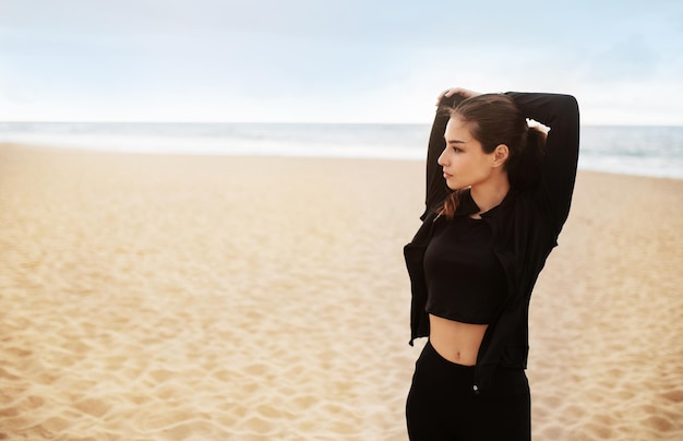 Outdoors workout fit young lady training outside stretching arm muscles getting ready for jogging on