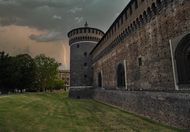 Outer wall of the Sforza's Castle Castello Sforzesco and a corner tower on a stormy day