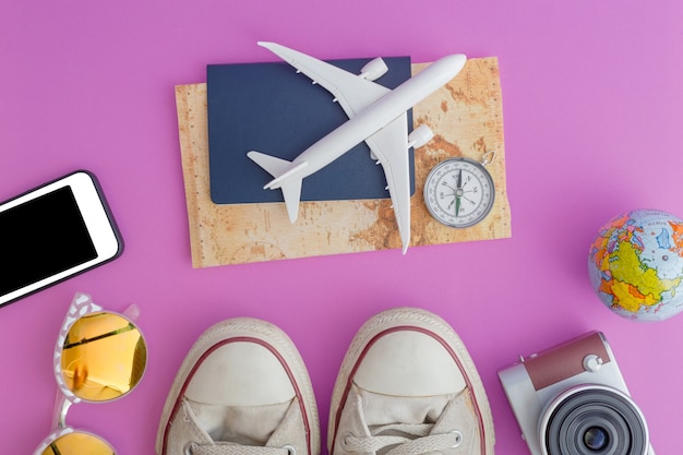 Outfit and accessories of traveler on pink background with copy space, Travel concept