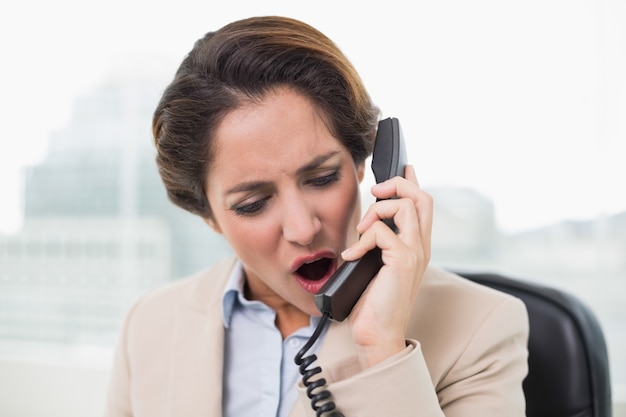 Outraged businesswoman shouting into phone