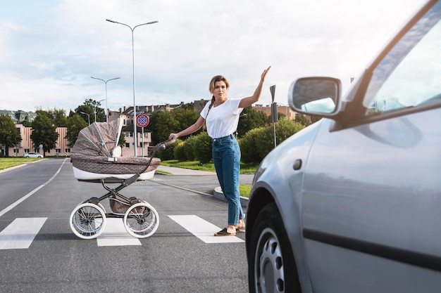 Outraged mother with the baby pram conflicting with a car\'s\
driver on the crosswalk