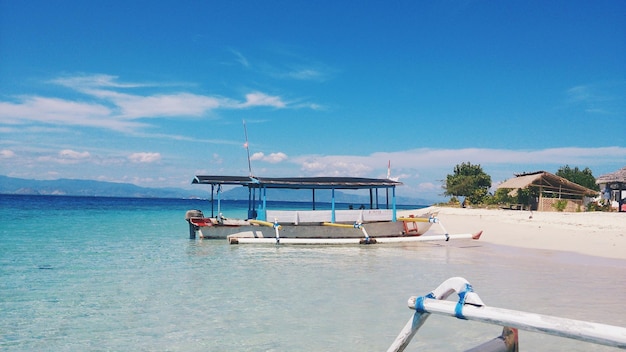 Foto outrigger sulla spiaggia contro il cielo blu