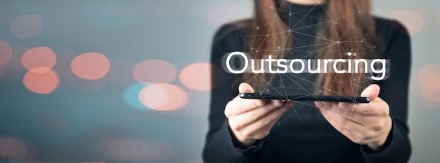 Outsourcing and phone in woman's hand