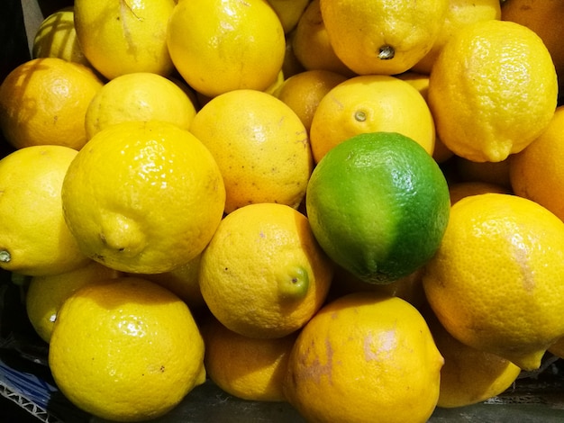 Outstanding green lime on top of yellow lemons backgroud