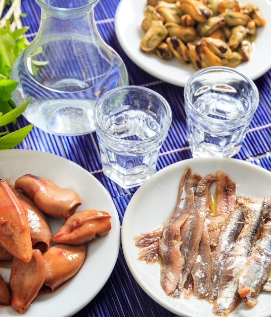 Ouzo raki alcohol with seafood meze vertical view