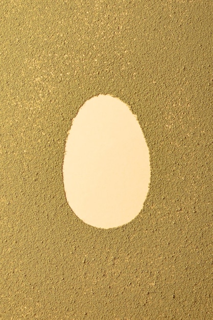 Photo oval easter egg silhouette made from matcha tea on green textured background minimalism