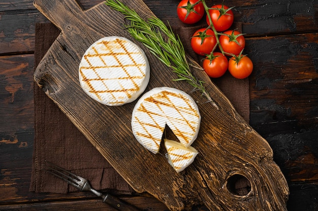 Camembert con retro del forno su vecchio tavolo in legno scuro sfondo vista dall'alto piatto laico