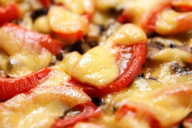 Oven baked chicken fillet with mushrooms, tomatoes and melted cheese. Meat dish with cheese and vegetables from the oven close-up