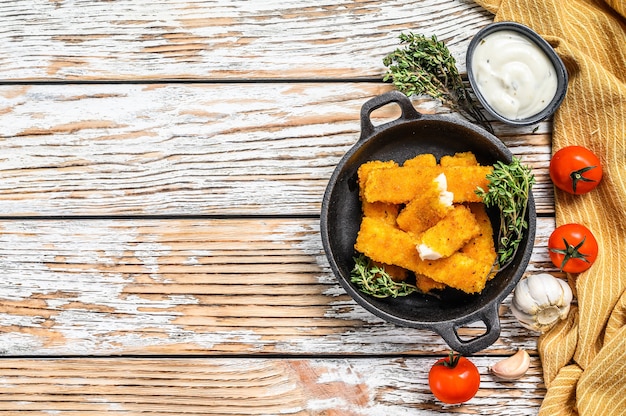 Oven baked crumbed fish sticks made from white fish.  White background. Top view. Copy space.