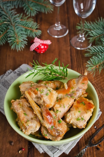 Photo oven baked rabbit legs with potatoes and rosemary. rustic style