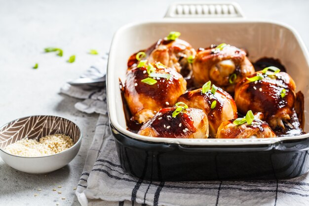 Oven-baked teriyaki chicken with green onions and sesame seeds.