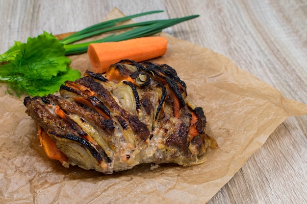 Ovenbaked pork slices with vegetables on a wooden table background