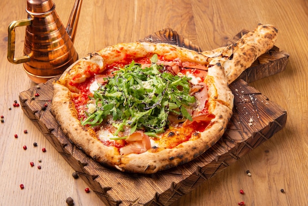 Ovengebakken pizza met mozzarella kaas gedroogde ham tomaten balsamico azijn en rucola