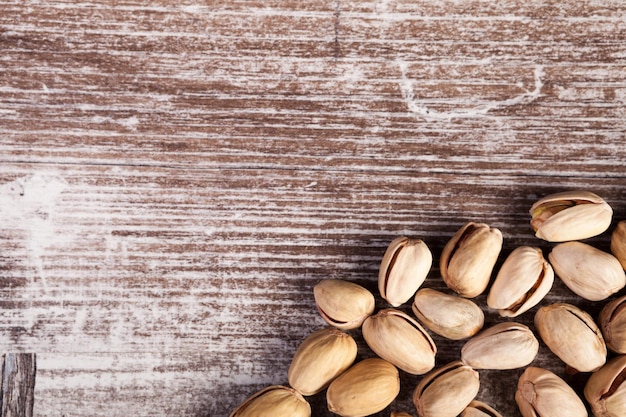 Over top close-up weergave van pistachenoten op houten achtergrond in studio foto. Gezonde heerlijke snacks