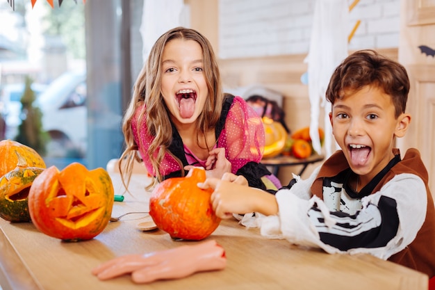 感情的な子供たち。ハロウィーンの衣装を着た黒髪の兄と妹は感情的すぎると感じています