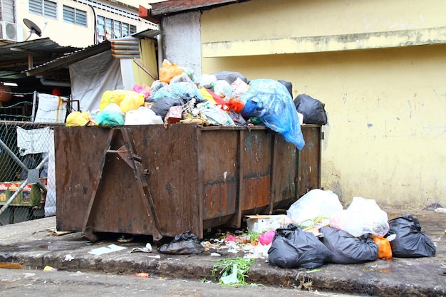 Overfull garbage bin by the road