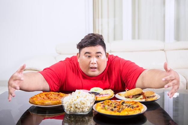 Overgewicht man knuffelen op veel ongezond voedsel