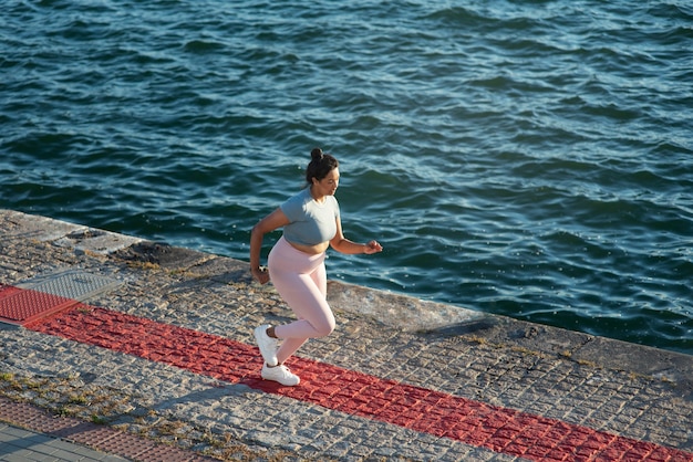 Overgewicht vrouw joggen buiten bij het meer