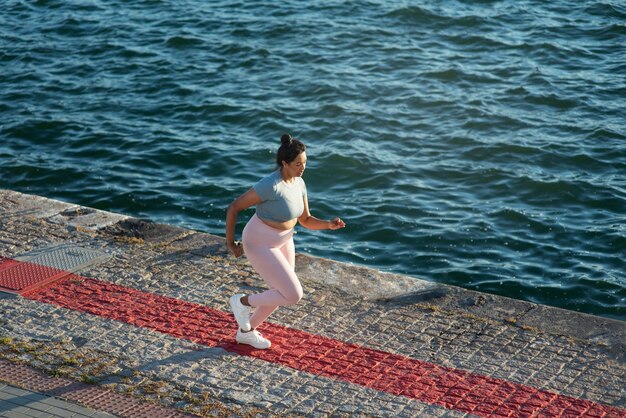 Overgewicht vrouw joggen buiten bij het meer